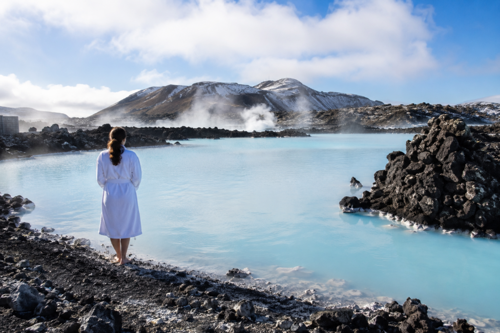 Turquoise geothermal lagoon water against black lava rock in Iceland