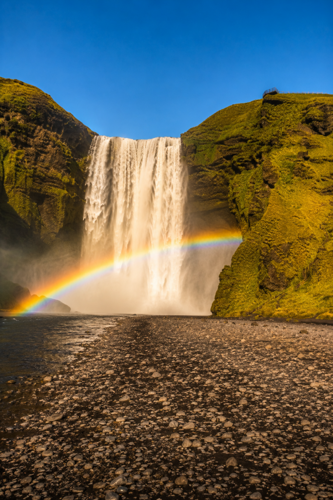 Skogafoss waterfall with a rainbow across the spray at golden hour