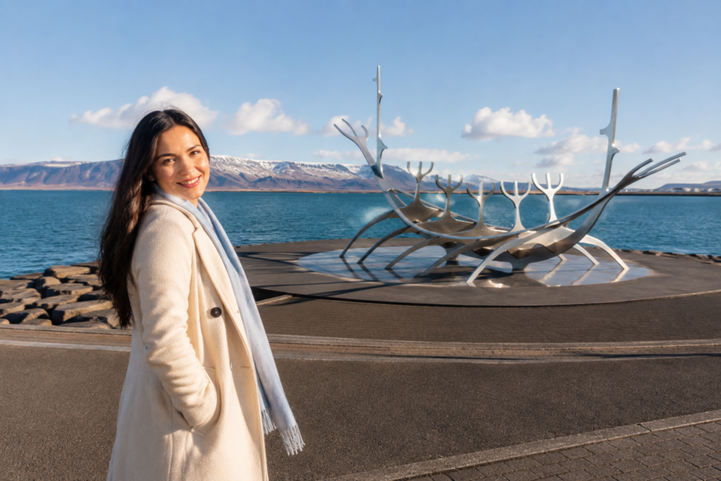 Woman walking along the waterfront near the Sun Voyager sculpture in Reykjavik at golden hour